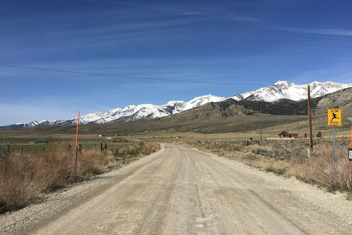 Gravel Ruby Valley Road heading south toward snowy Ruby Mountains
